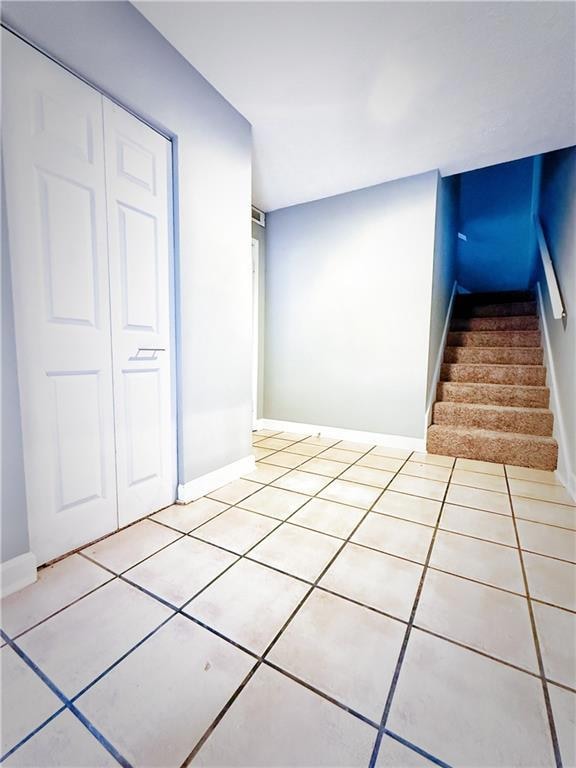 Stairs with baseboards and tile patterned floors