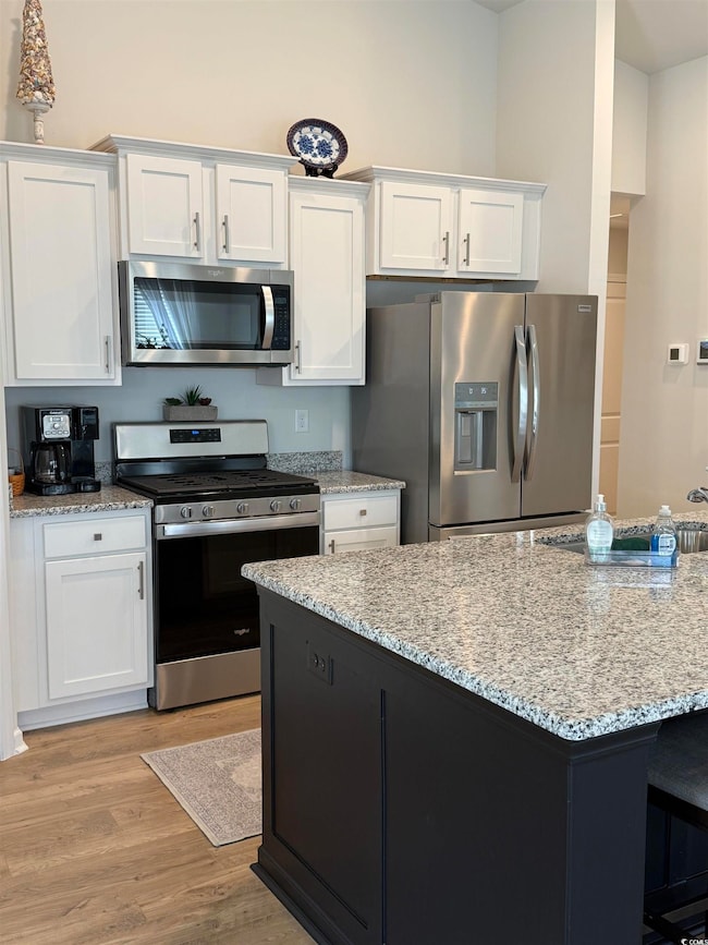 Kitchen with stainless steel appliances, white cab