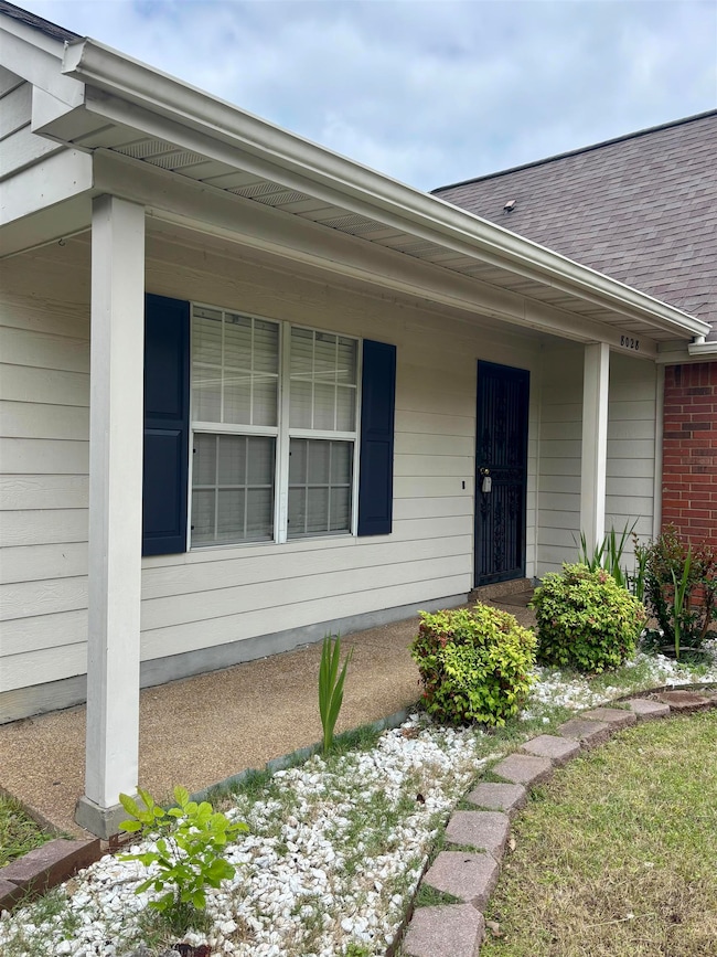 Property entrance with roof with shingles and covered porch