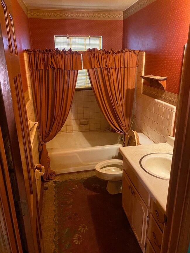 Full bathroom with toilet, shower / bath combo wit