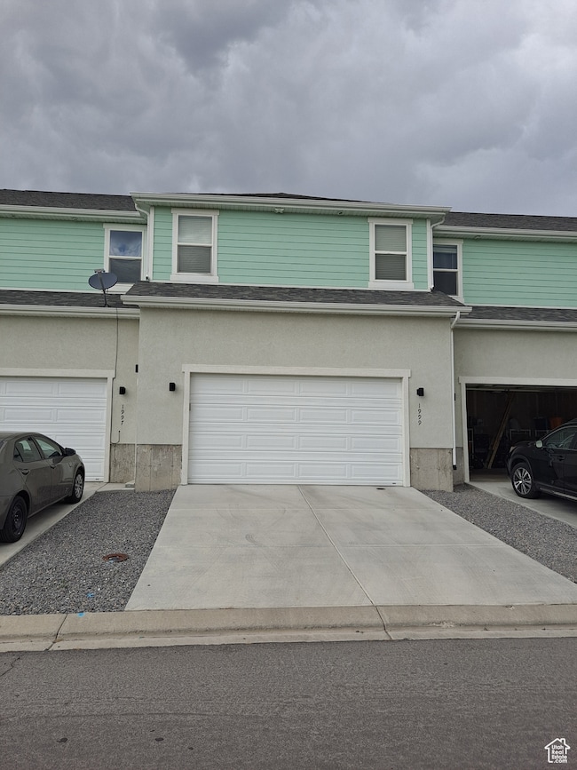 View of property exterior with a garage and driveway
