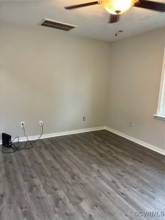 Empty room featuring baseboards and dark wood-type