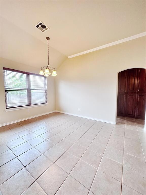 Tiled empty room with vaulted ceiling, a notable c