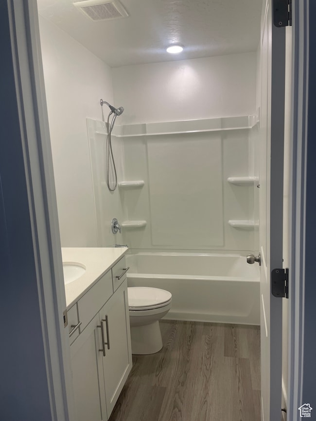Bathroom featuring bathing tub / shower combination, vanity, and dark wood-style floors