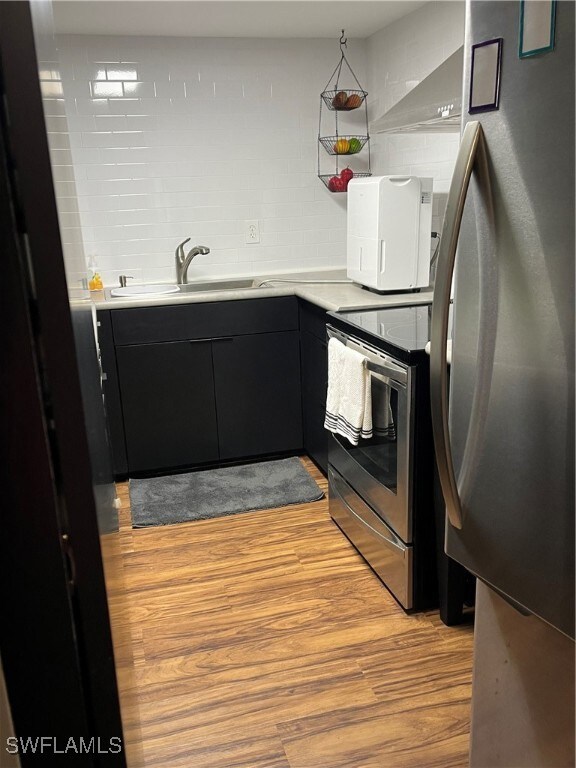 Kitchen featuring refrigerator, range, dark cabine