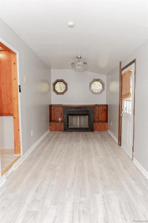 Unfurnished living room featuring a fireplace and light wood-style flooring