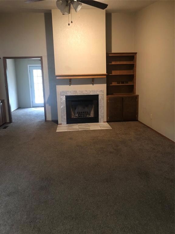 Living room has vaulted ceiling, wood-burning fireplace and 2 built-in bookshelves