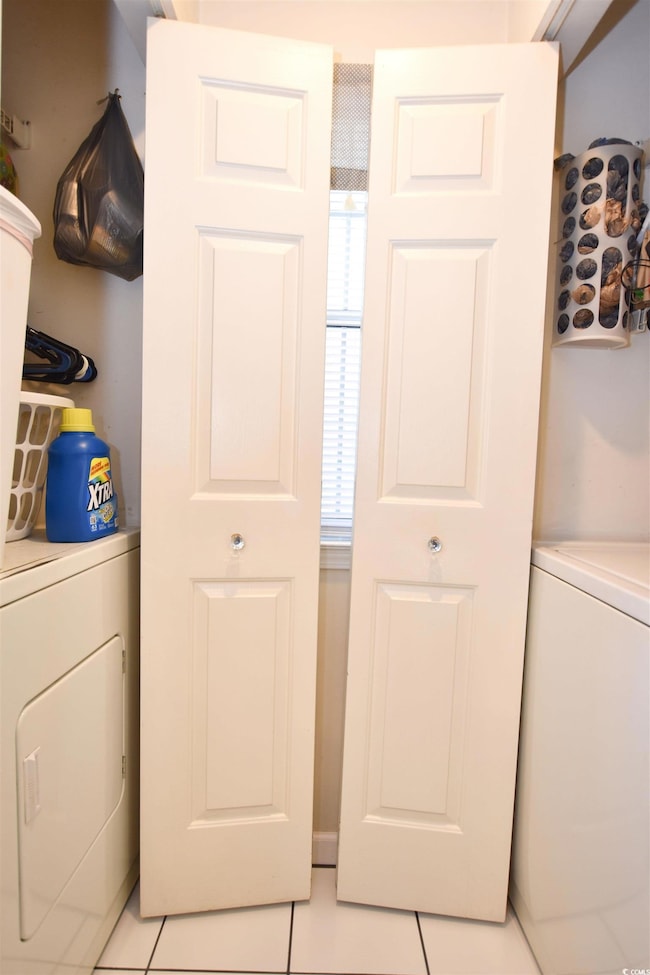 Clothes washing area with light tile patterned flo
