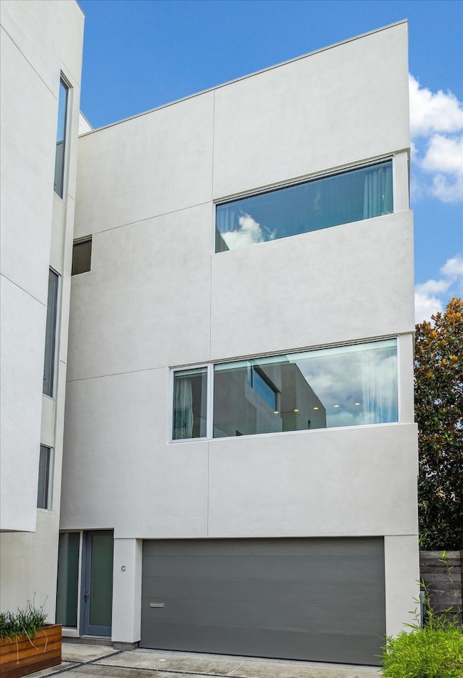 Modern four-story townhouse with a sleek, minimalist design featuring large RAM casement windows and a two-car garage. Perfect for urban living with a contemporary aesthetic.