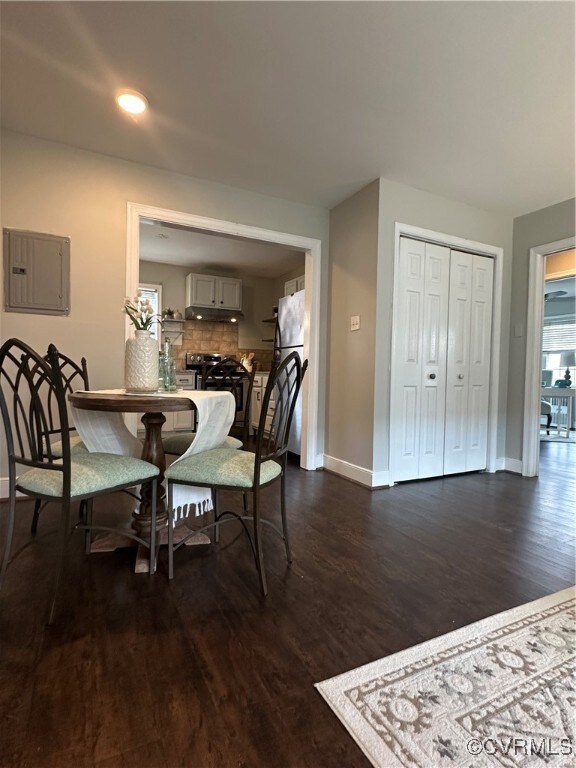 Dining space with dark wood-style flooring, electr