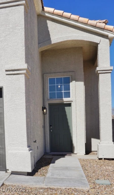 Entrance to property featuring stucco siding