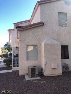 Back of property featuring cooling unit and stucco