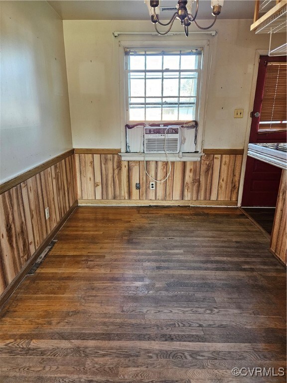 Unfurnished dining area with cooling unit, wood wa