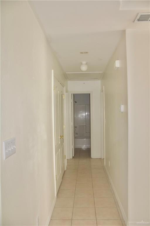 Hallway with light tile patterned floors and baseboards