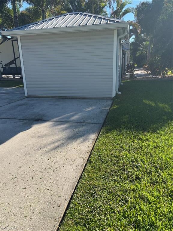 View of home's exterior with a lawn and a metal roof