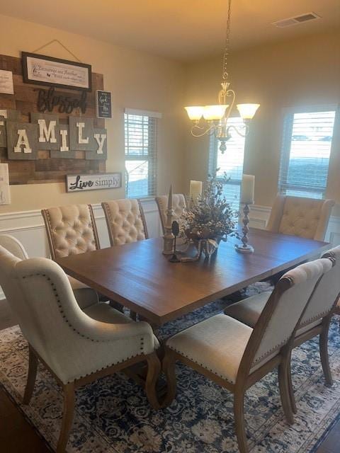 Dining room featuring visible vents, a chandelier,