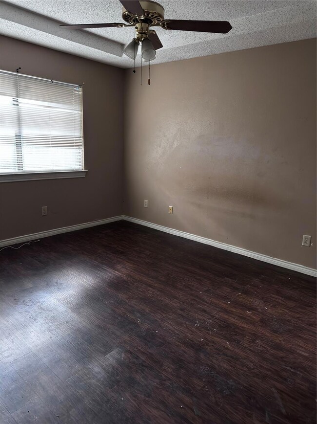 Spare room with a textured ceiling, wood-type floo