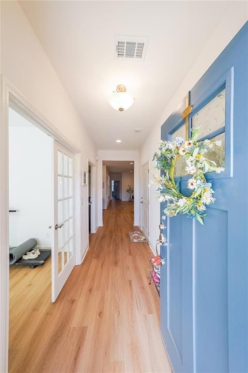 Corridor featuring visible vents, light wood-style