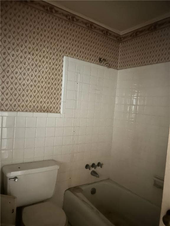Bathroom featuring wallpapered walls and shower / bath combination