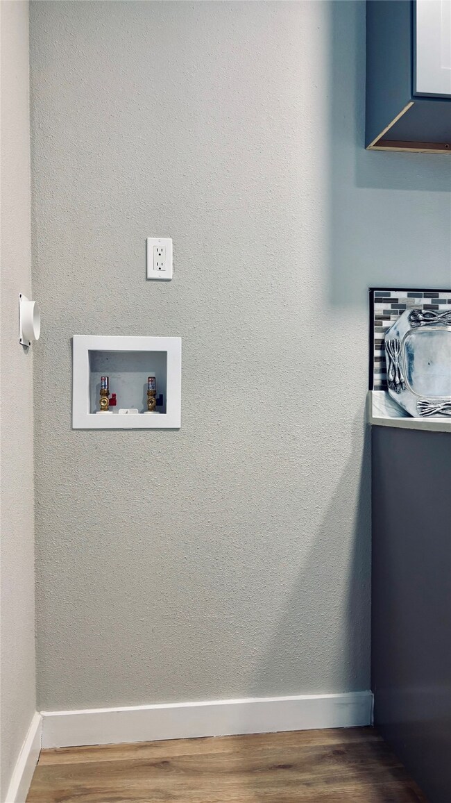 Kitchen with wood finished floors and washer hookup.