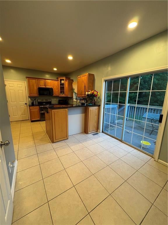 Kitchen with range, dark countertops, a peninsula,