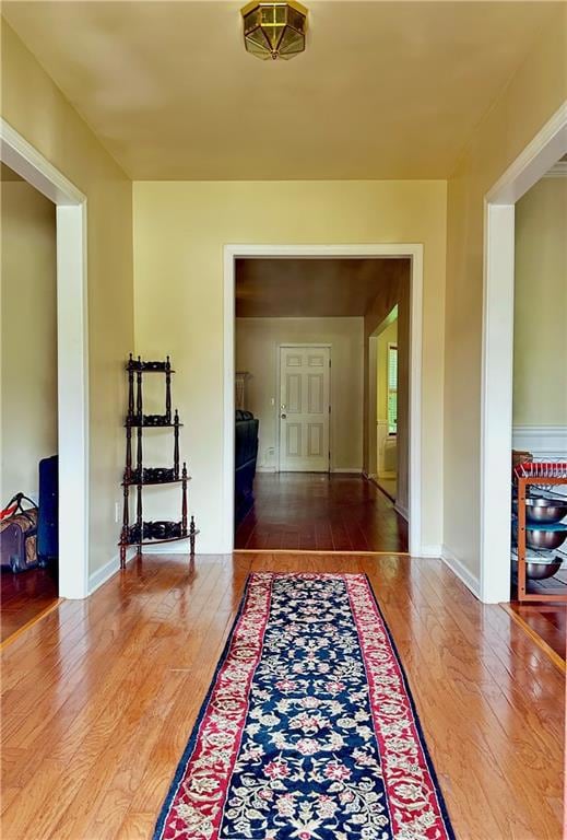 Dining room with crown molding, a chandelier, wood finished floors, and a wainscoted wall