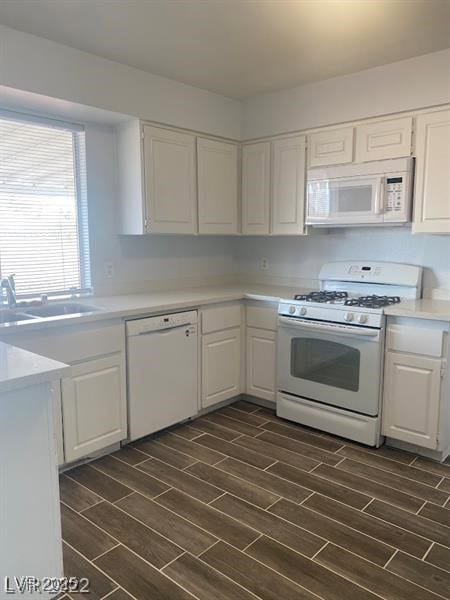 Kitchen featuring white appliances, white cabinetr