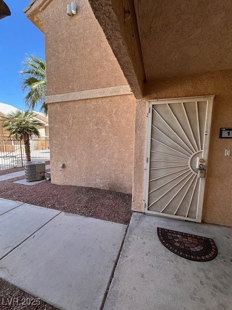Entrance to property featuring stucco siding and c