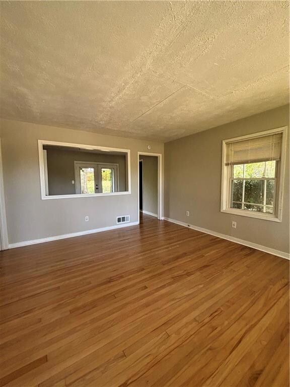 Unfurnished room featuring visible vents, a textur