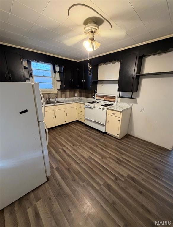 Kitchen featuring dark cabinets, white appliances, open shelves, and dark wood-style floors