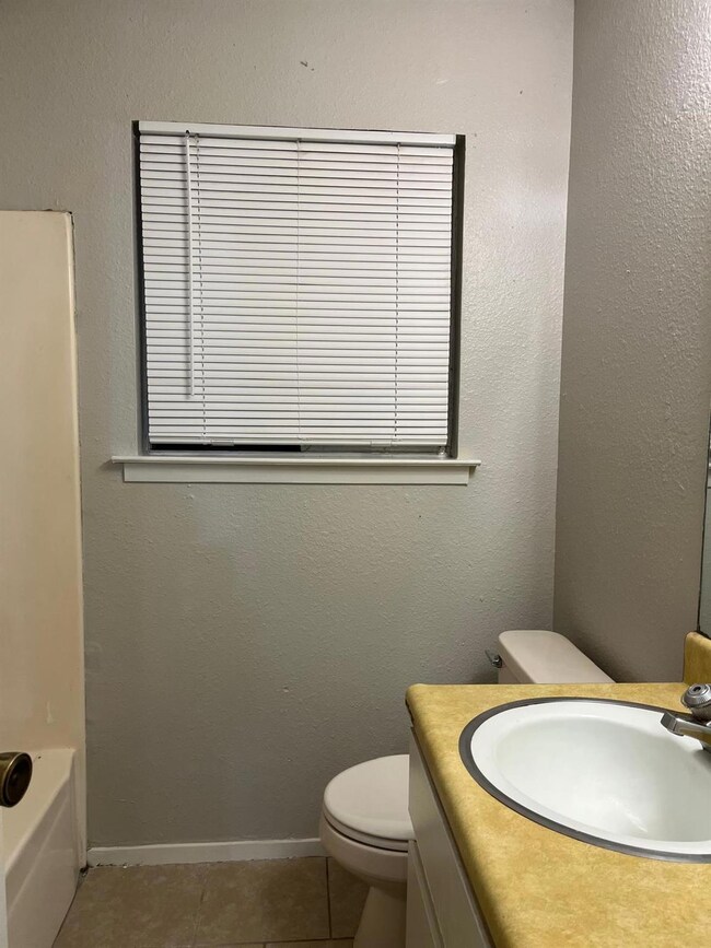 Full bathroom with a textured wall, vanity, and tile patterned floors