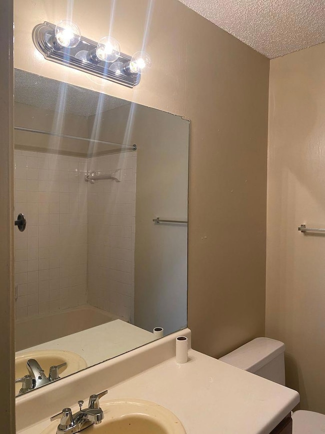 Bathroom featuring walk in shower, a textured cei