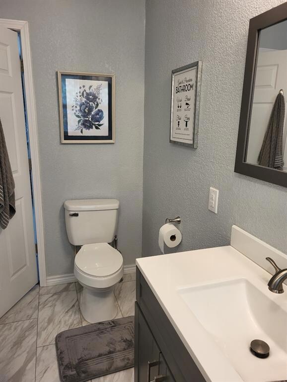 Bathroom featuring vanity, toilet, and tile floors