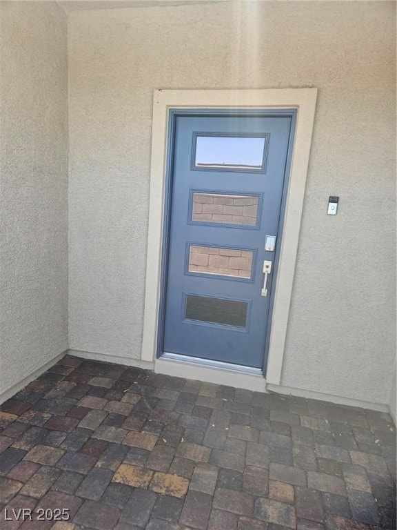 View of exterior entry featuring stucco siding