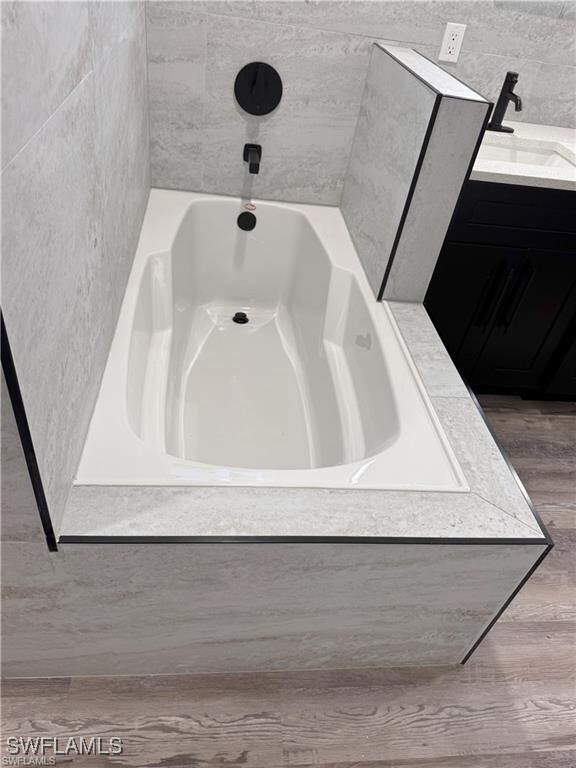 Bathroom featuring a bathtub, wood finished floors