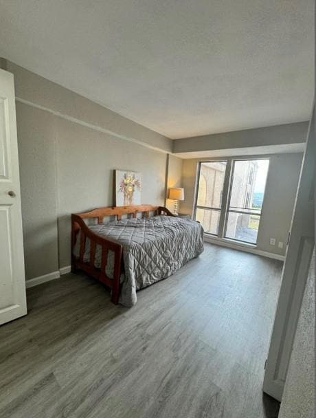 Bedroom with a textured ceiling, wood finished fl