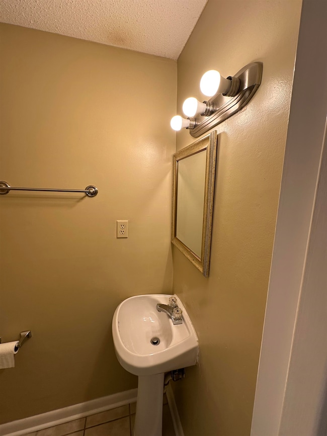 Bathroom featuring tile patterned floors and a textured ceiling