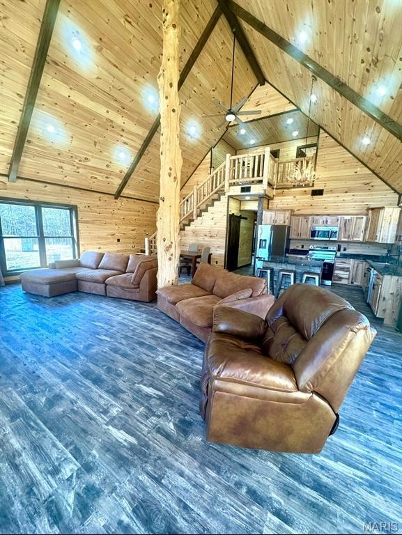 Living area featuring wood walls, high vaulted ceiling, dark wood finished floors, a wooden ceiling with exposed beams, and stairway