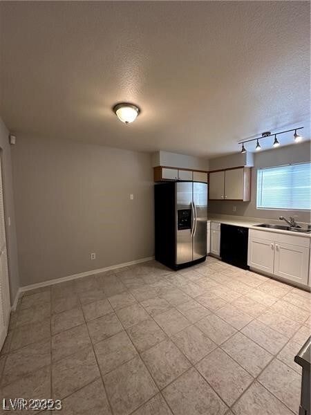 Kitchen featuring light countertops, black dishwas