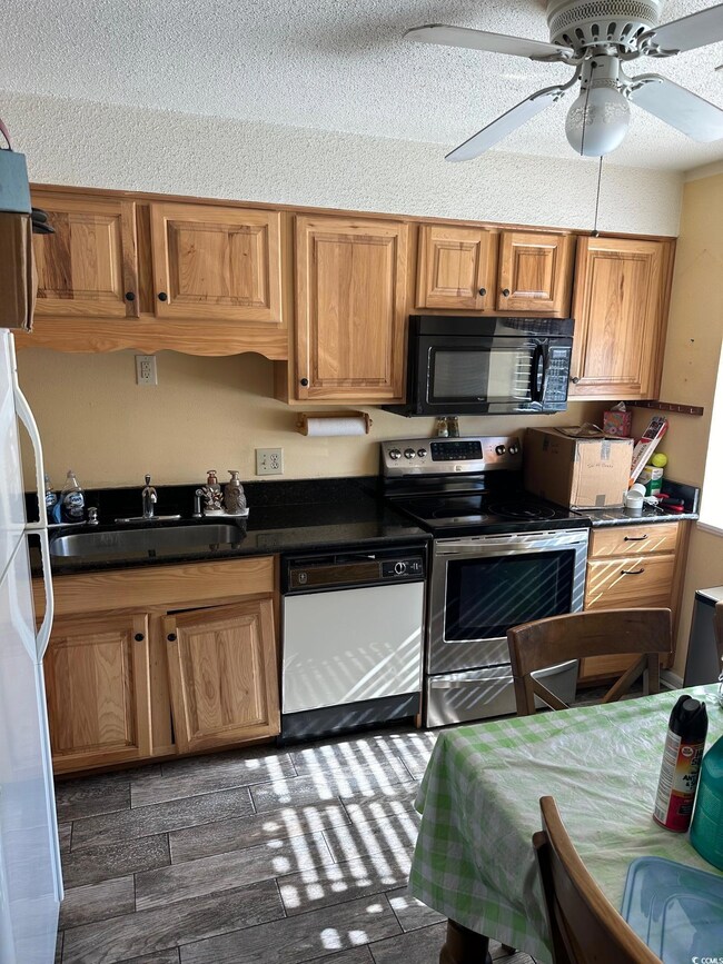 Kitchen with dishwashing machine, a textured ceili