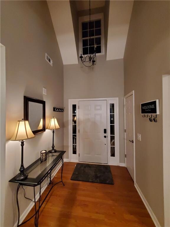 Foyer with hardwood / wood-style floors and high v