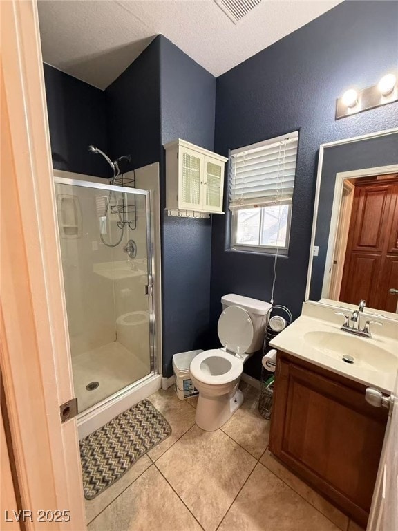 Bathroom with a stall shower, toilet, vanity, tile