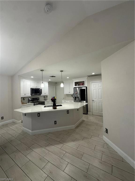 Kitchen with refrigerator, white cabinetry, hangin