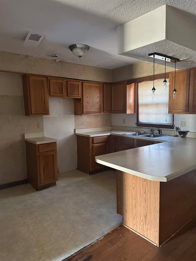 Kitchen with a peninsula, brown cabinetry, visible