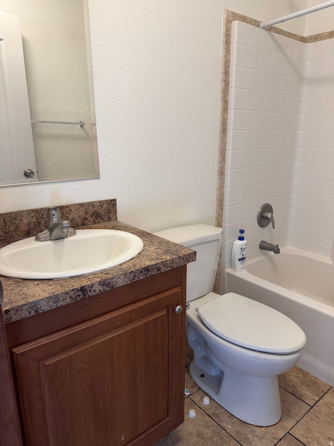 Full bath with shower / washtub combination, vanity, and tile patterned flooring