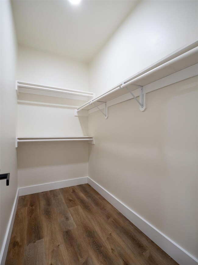 Walk in closet with wood finished floors