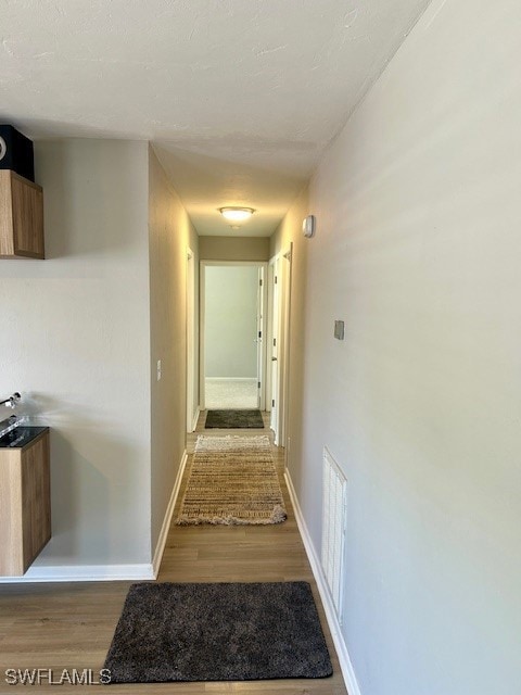 Hall featuring light wood-style flooring and baseb