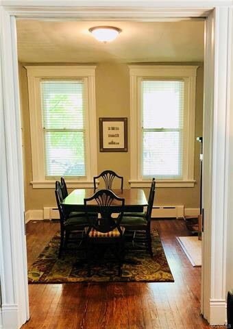 Large front parlor used as a dining room with fireplace, arched entry, and pocket doors!