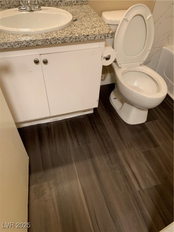 Bathroom featuring toilet, wood finished floors, a