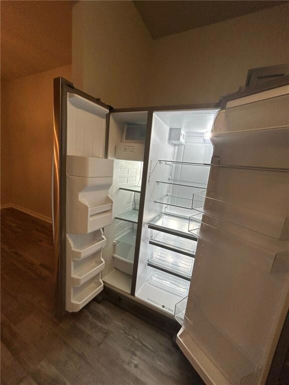 Walk in closet with dark hardwood / wood-style flo